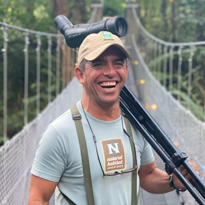 A photo of the expedition leader smiling with a camera tripod in his hand