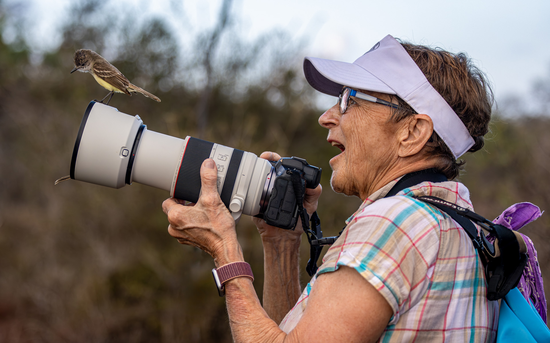 woman photographing finch in Galapagos